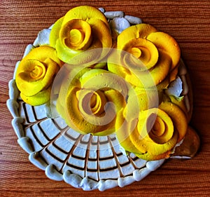 Butterscotch cake with yellow flowers on top.