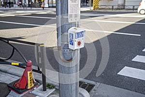 A button for the elderly and disabled to cross to the other side of the street. Tokyo. Japan.