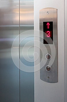 The button for the elevator and the screen with a number shows the floor and direction.