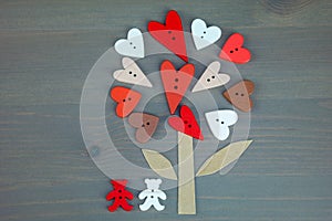 Button love tree and two bears on grey wooden background.