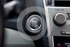 Button start and turn off the ignition of the car engine close-up on the dashboard, electric key, of modern design black and with