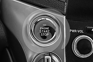 Button start and turn off the ignition of the car engine close-up on the dashboard, electric key, of modern design black and with