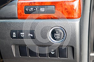 Button start and turn off the ignition of the car engine close-up on the dashboard, electric key, of modern design black and with