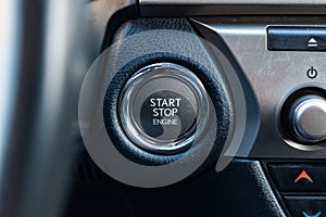 Button start and turn off the ignition of the car engine close-up on the dashboard, electric key, pressing drives the motor