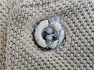 Button on a vintage dull brown shirt close up