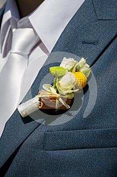 Buttonhole of the groom from beige roses and cinnamon