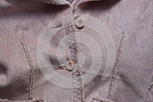 Buttons on a brown suede winter jacket with fur