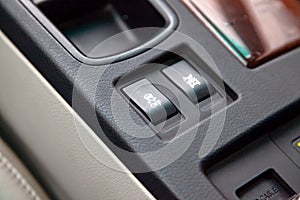 The buttons of the course control system are black and with white signs close-up in the interior of the car on the control console