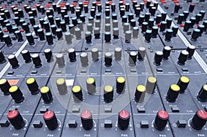 Buttons, levels, switches, speaker volume control on an audio mixer control panel set at the TV studio
