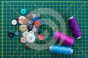 Buttons and thread on a mat cutting