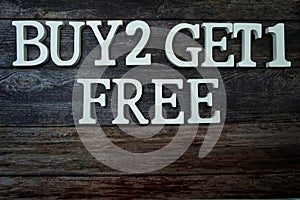 Buy 2 Get 1 Free with space copy on wooden background