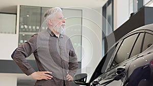 Buy car, man examine choose new automotive in showroom, look closely on exterior. Old male