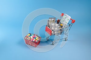 Buy medicine. Shopping basket with various medicinal, pills, tablets on blue background. Studio Photo