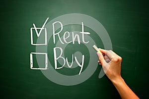 Buy not rent concept on green blackboard