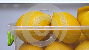 Buy organic. Yellow lemons in icebox. Vitamin C. Copy space. Lemons keep freshness in the fridge. Lemons ready to use