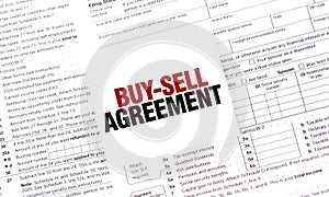 BUY-SELL AGREEMENT on white sticker with documents