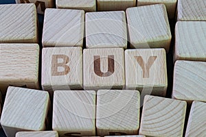 Buy and sell for consumerism, spend money to get new products concept, cube wooden block with alphabet combine the word Buy on