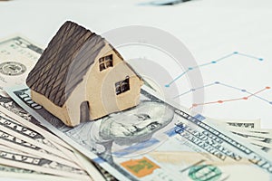 Buy and sell house or real estate, home loan, mortgage and property investment concept, miniature house on pile of US dollar bank