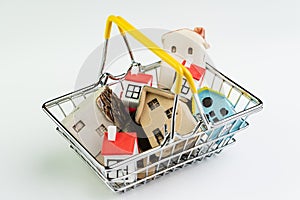 Buy and sell house or real estate purchasing concept, shopping basket with full of small cute miniature houses on white background