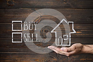 Buy or sell house written on wooden boards.