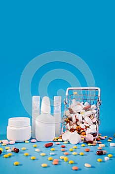 Buy and shopping medicine concept. Various capsules, tablets and medicine in the shopping cartt on a blue background