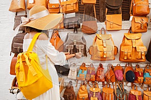 Buyer chooses a backpack on the market in the shop of leather Handicrafts