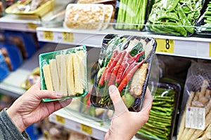 Buyer chooses fresh vegetables in shop