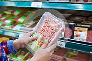 Buyer chooses minced meat in store