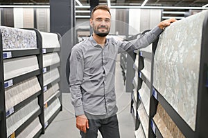 the buyer chooses wallpaper in the store for renovation goods