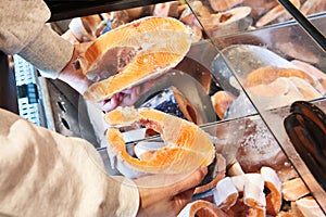 Buyer hand with frozen red salmon fish