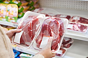 Buyer hands with beef meat packages at grocery