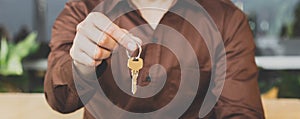 The buyer holds the house key received from the salesperson after signing the purchase contract.