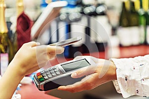 The buyer pays for the item at the cash register using a smartphone. Close-up Contact-Free Payment Process