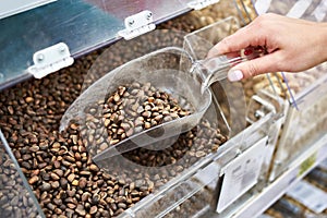 Buyer with scoop takes pine nuts in store