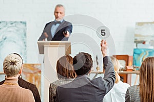 Buyer showing auction paddle with number