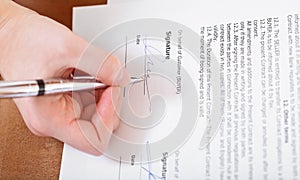 Buyer signs a contract by silver pen