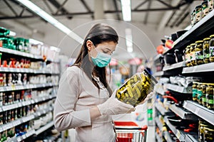 Buyer wearing a protective mask.Shopping during the pandemic quarantine.Nonperishable smart purchased household pantry groceries
