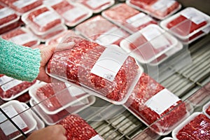 Buyer woman chooses chopped meat in shop