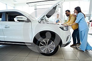 Buyers inspect the car under the hood