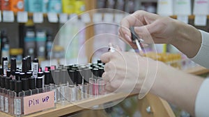 Buying cosmetics in the store. Woman Choosing color cosmetics in the store. Woman uses makeup tester.