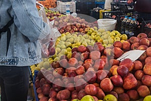 Buying fresh organic produce at the farmers& x27; market. A woman chooses fresh herbs, vegetables and fruits at a food