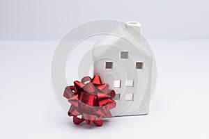 Buying house concept, investment in property. White home with red bow