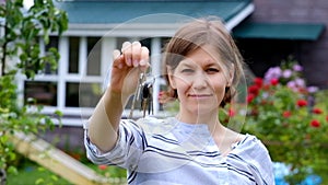Buying house concept. Woman holding keys from new house.