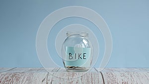 Buying new bike. Planning budget. Money saved for bike in glass jar. Saving money concept