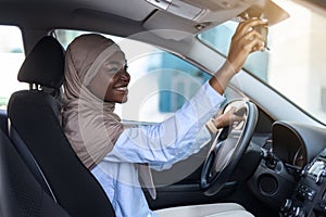 Buying New Car. Muslim African Lady In Hijab Adjusting Rear View Mirror