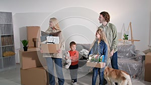 buying or renting real estate, young family with a dog walking in new apartment with cardboard boxes, happy couple with