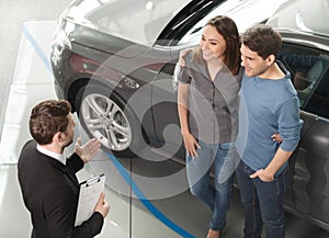 Buying their first car together. High angle view of young car sa