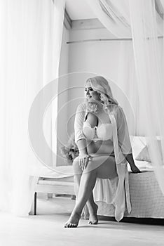 Bw blonde girl plus size sitting on the bed in white lingerie portrait of Bali morning bride