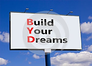 BYD build your dreams symbol. Concept words BYD build your dreams on big white billboard against beautiful blue sky background.