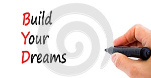 BYD build your dreams symbol. Concept words BYD build your dreams on white paper on a beautiful white background. Businessman hand